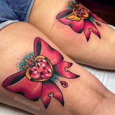 two women's legs with tattoos on them, one has a heart and the other has a crown