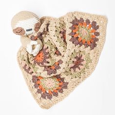 a crocheted blanket with a stuffed animal on it