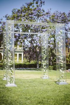 an outdoor ceremony area with clear plastic structures and flowers