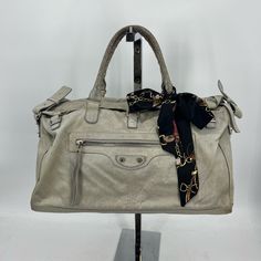 Balenciaga Boston Bag Grey With Silver Hardware Measures Approx 17.5”X8” Handles Measure Approx 7” Shoulder Strap Measures Approx 18” Shoulder Strap Is Adjustable And Removable 1 Exterior Pocket 1 Interior Compartment Features 1 Zipper Pocket Zippers Are Functional 3 Snap Button Closure Flap Has Zipper Underneath Silky Ribbon Included Item Shows Signs Of Wear From Normal Use- Cracked Leather Throughout, Worn Corners, Wearing On Handles, Tarnished Hardware Please Refer To Photos For Further Details. Jp083008 Balenciaga Travel Bag, Bags Balenciaga, Balenciaga Bag, Boston Bag, Balenciaga City Bag, Silver Hardware, Snap Button, Travel Bags, Zipper Pocket