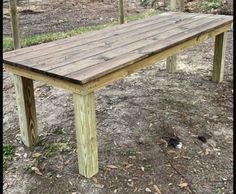 a wooden table sitting on top of a dirt field