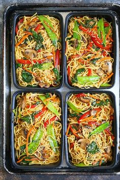 four black trays filled with different types of noodles and vegtables in them