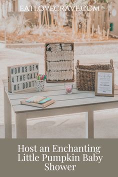 a wooden table topped with books and baskets next to a sign that says host an enchanting little pumpkin baby shower