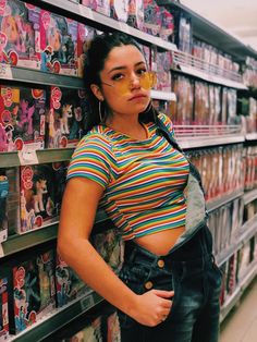 a woman standing in front of a store shelf with her hands on her hips and looking at the camera