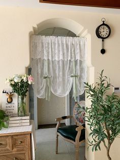 a living room with a clock on the wall and flowers in vases sitting next to it