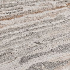 an area rug with different colors and patterns on the floor, including greys, browns, yellows and white