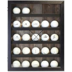 a wooden shelf with several different types of golf balls on it and a clock in the middle