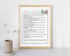 a family rules poster next to a vase with flowers in it on a white surface