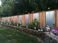 an image of a fence that is made out of wood planks and concrete blocks