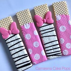 four decorated candy bars with pink bows and polka dots on them, all lined up in the same row