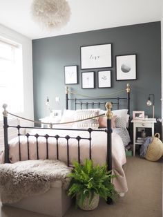 a bed room with a neatly made bed and some pictures on the wall above it