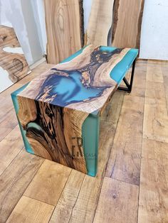 a wooden bench sitting on top of a hard wood floor covered in blue and white paint