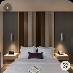 a bed with two nightstands and a book on it