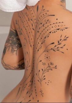 the back of a woman with tattoos on her body