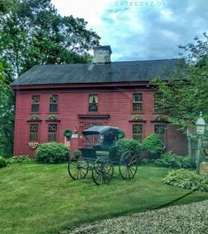 a horse drawn carriage parked in front of a red house