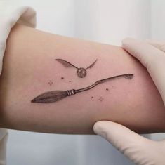 a knife and fork tattoo on the left side of the right arm, which is being held up by someone's hand