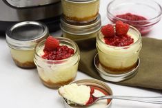 small jars with raspberry cheesecake in them