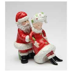 two santa claus figurines sitting next to each other