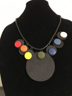 Multicultural, multicolored foam rubber necklace with wood beads and an adjustable 2 inch chain with lobster claw closure. 23 inches long with 14.5 drop (laying flat). Very light weight. 6 1 inch small pendant  with .75 inch wooden bead  and large 3 inch pendant with wooden bead. Light Weight Necklace, Rubber Necklace, Bold Color, Small Pendant, Durham, Wooden Beads, Wood Beads, Lobster Claw, Bold Colors