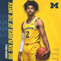 a young man holding a basketball on top of a yellow and blue cover with the michigan wolverines logo