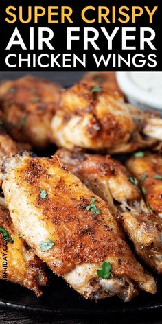 grilled chicken wings on a black plate with text super crispy air fryer chicken wings