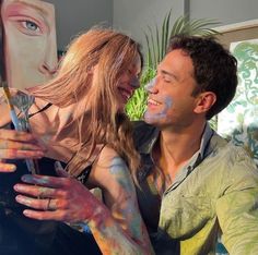 a man and woman with their faces covered in paint