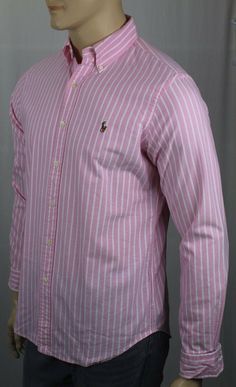 Ralph Lauren Pink Striped Classic Oxford Shirt Multi Colored Pony NWT -Ralph Lauren- -New with Tags- -Long sleeved button-down shirt, cut for a Classic fit. -Tailored from 100% Cotton in Pink Cream Striped Pattern -Button-down collar, split back yoke, shirt tail hem. -Embroidered Multi Colored Pony on chest -Machine washable.   ~Measurements~     Small Medium Large X-Large XX-Large ARMPIT TO ARMPIT 22" (55.9 cm) 23.5”(59.7cm) 25” (63.5 cm) 26” (66 cm) 28.5”(72.4cm) SHOULDER TO FRONT HEM 29” (73. Striped Long Sleeve Shirt For Spring, Long Sleeve Shirt With Placket For Spring, Striped Long Sleeve Shirt For Daywear, Spring Long Sleeve Top With Placket, Spring Striped Slim Fit Shirt, Pink Collared Slim Fit Top, Pink Slim Fit Collared Top, Pink Slim Fit Button-up Tops, Slim Fit Long Sleeve Shirt For Spring