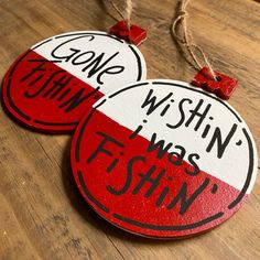 two red and white tags with words on them sitting on a wooden table next to string