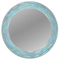 a round mirror with blue and green tiles on the bottom, in front of a white background