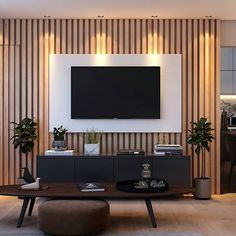 a living room with a large television mounted on the wall and two planters in front of it