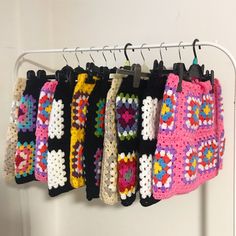 there are many crocheted items hanging on the rack