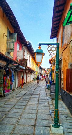 an empty street with people walking down it and shops on both sides, in the middle of town