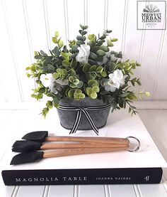 a potted plant sitting on top of a table next to two gardening utensils