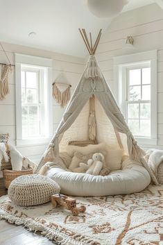 a white room with a teepee and pillows on the floor