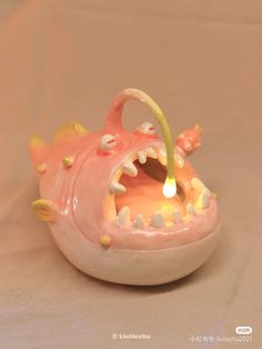 a pink toy with teeth and spikes on it's head