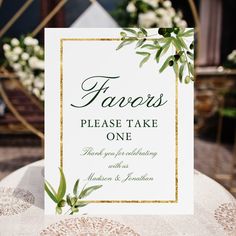 a sign that says favors please take one on top of a table with flowers in the background