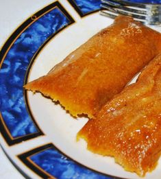 two pieces of food sitting on top of a white plate with blue and black trim