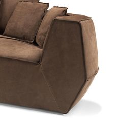 a brown couch sitting on top of a white floor next to pillows and pillow cases