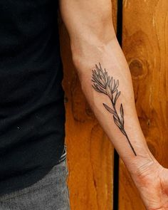 a person with a tattoo on their arm holding the hand of another person's wrist