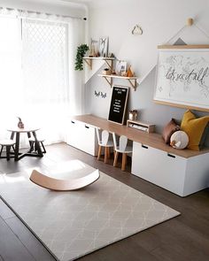 a living room filled with furniture and a white rug on top of a hard wood floor