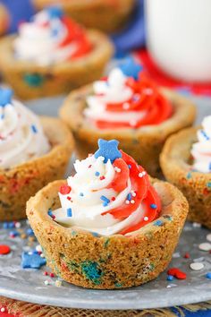 patriotic cupcakes with white frosting and sprinkles on a plate