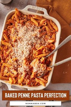 baked penne pasta in a casserole dish with parmesan cheese on top