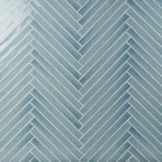 a close up view of a herringbone tile pattern in light blue and grey tones