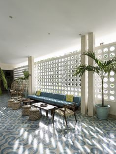 a living room filled with lots of furniture next to a wall covered in holes and circles