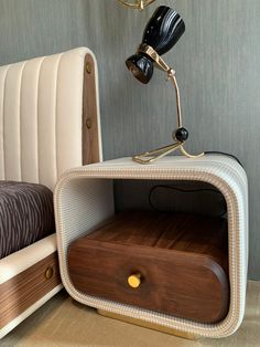 a lamp that is sitting on top of a wooden shelf next to a bed with a headboard