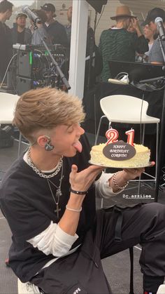 a woman holding a cake with the number one on it in front of her face