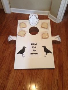 a cornhole game with two black birds on it and some cookies in the background