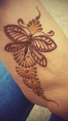 a woman's hand with a butterfly tattoo on it