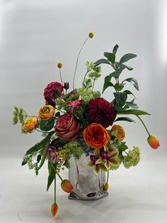 a vase filled with lots of different colored flowers