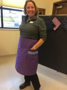 a woman wearing an apron and smiling for the camera